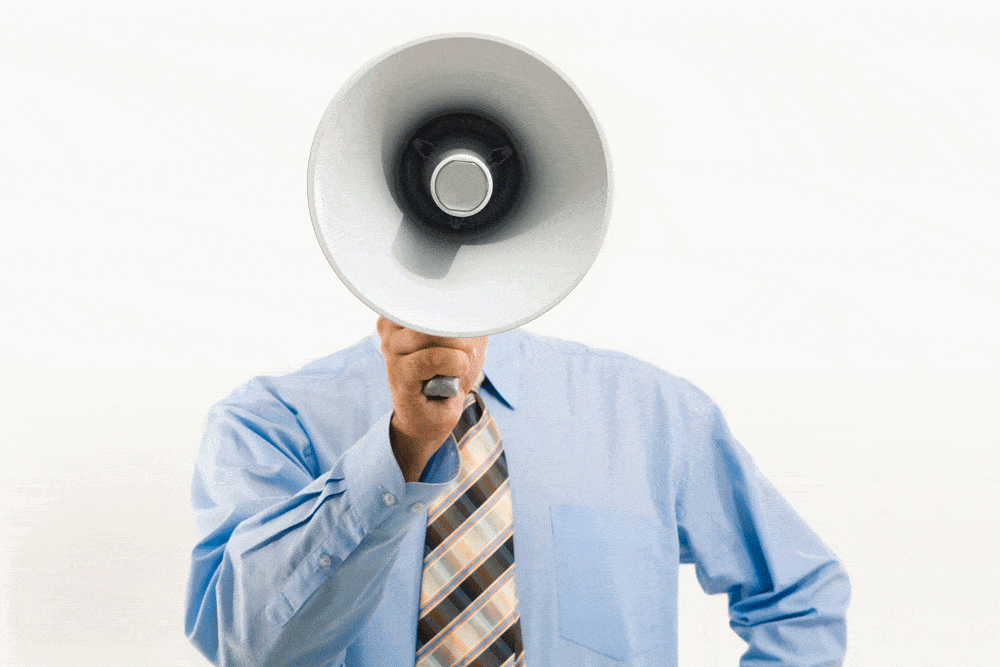 photo of man wearing tie holding up megaphone so face is not visible