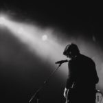 person stands on stage performing