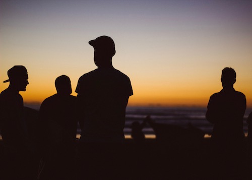 silhouette of people by ocean