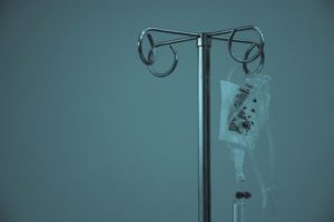 IV bag hanging from an IV pole in a dimly lit room
