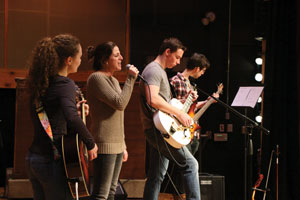 group of four musicians playing on a stage