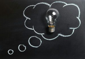 lightbulb on a chalkboard background. a thinking cloud is drawn around the lightbulb.