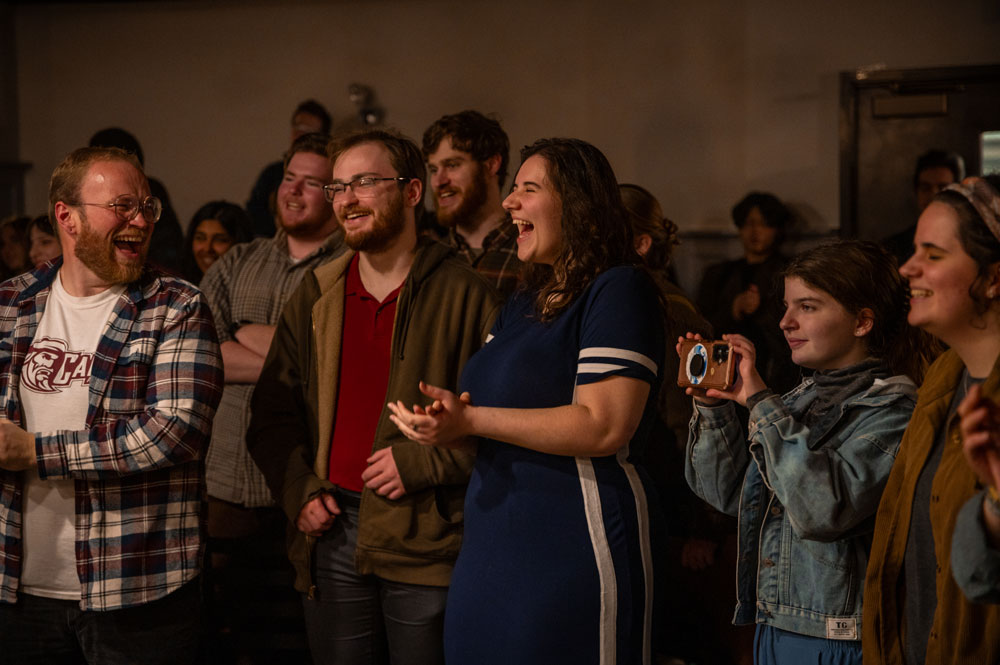 students laughing and smiling in the front row of a campus event